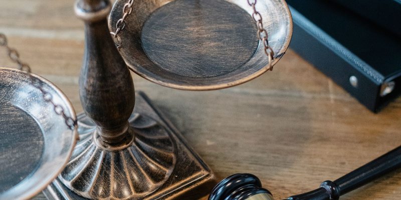 Balanza de bronce y mazo sobre un escritorio de madera — herencias y sucesiones