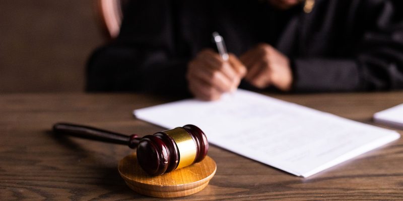 Documentos firmándose sobre una mesa junto a un mazo — derecho laboral