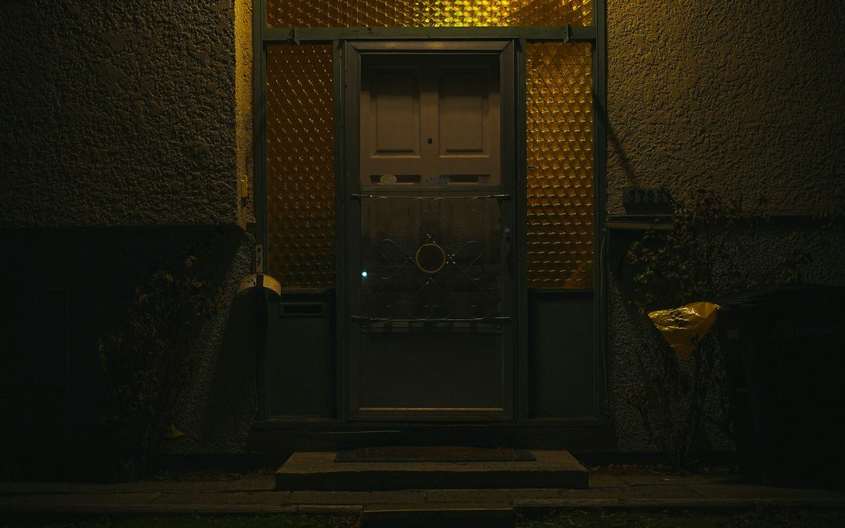 Portal de vivienda iluminado de noche durante una urgencia de cerrajería 24 horas
