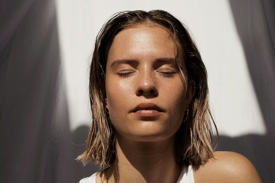 Retrato de una mujer con la piel luminosa y el pelo recogido tras una sesión facial