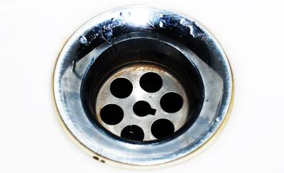 Desagüe cromado de un lavabo blanco visto desde arriba