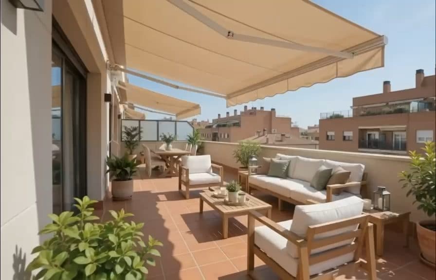 Terraza de ático amueblada con sofás de exterior, toldo y plantas
