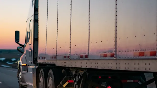 Camión de mudanzas circulando por carretera al atardecer
