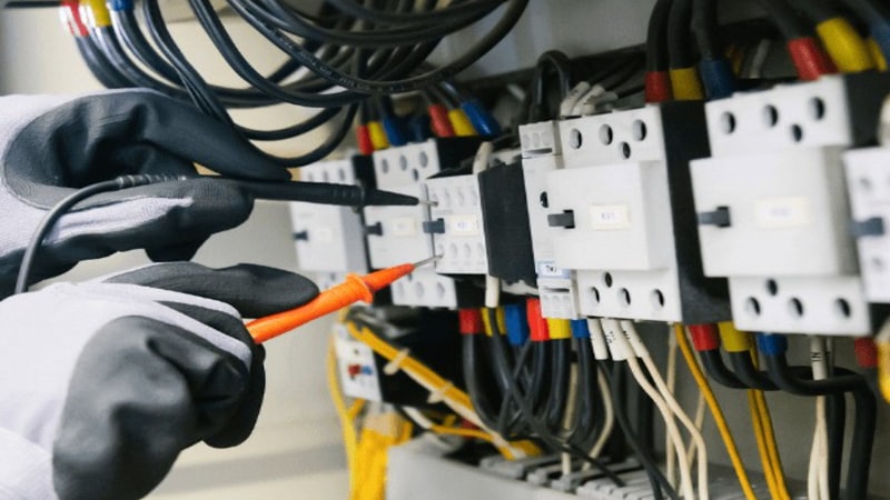Electricista comprobando con un multímetro los automáticos de un cuadro eléctrico