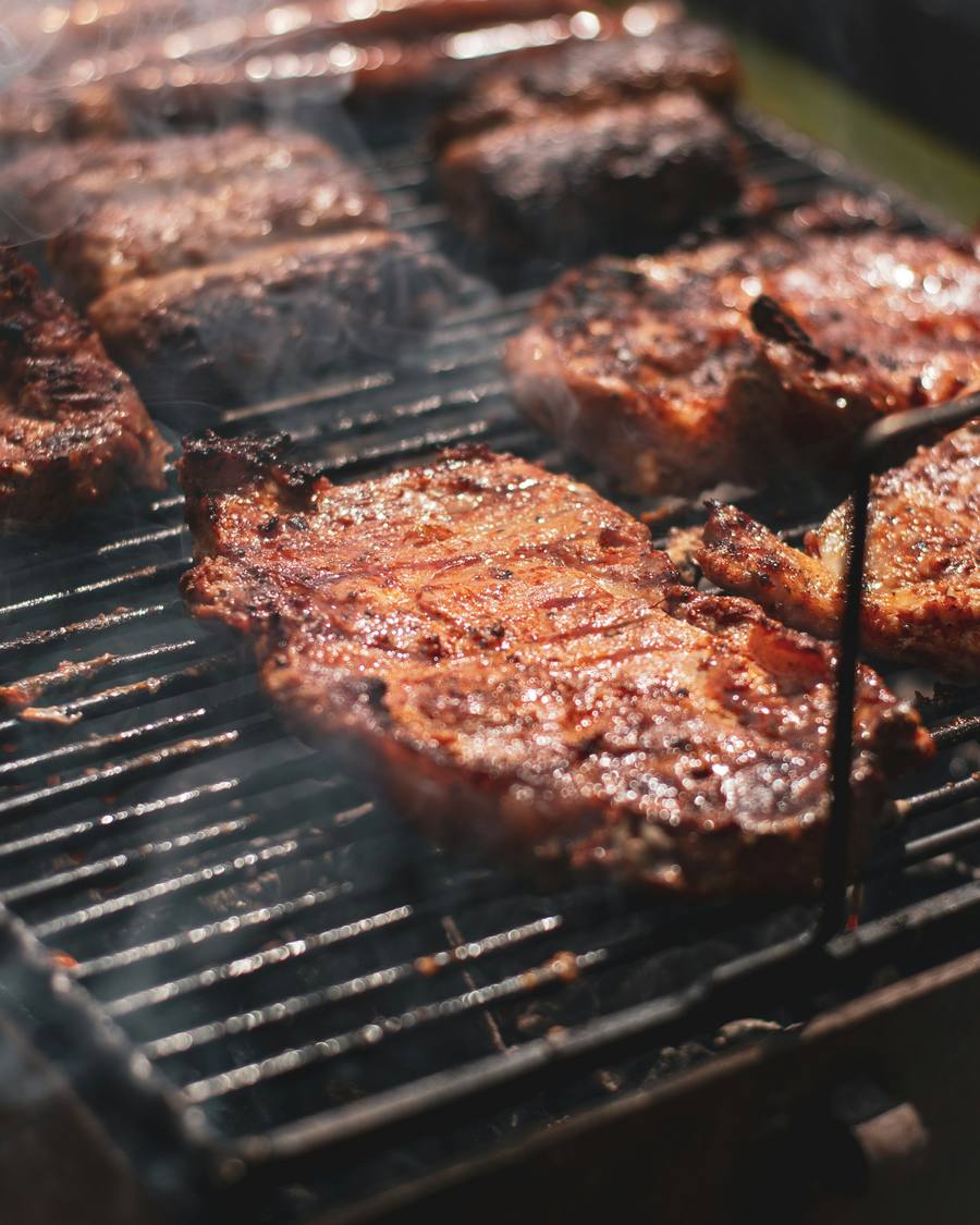 Cortes de carne marcándose sobre una parrilla de carbón.