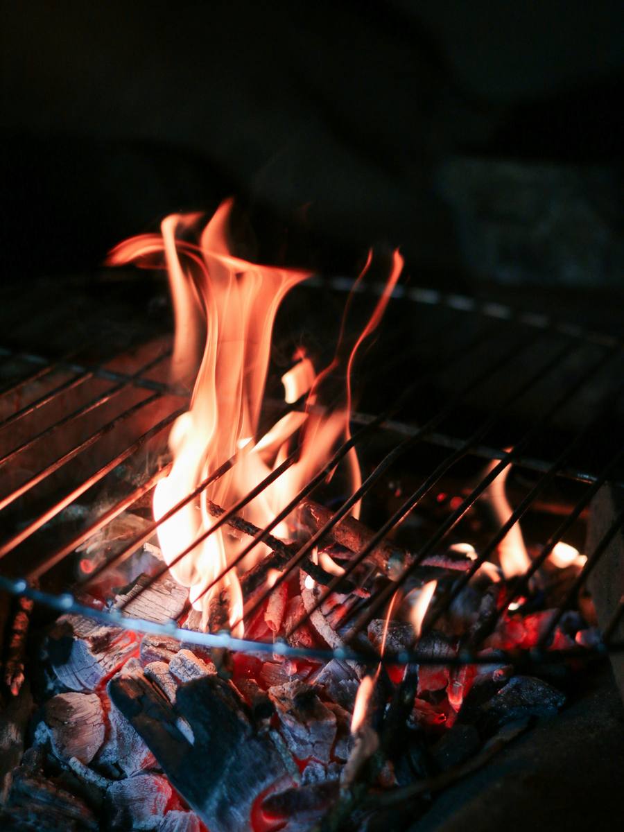 Llamas altas saliendo de una parrilla de carbón.