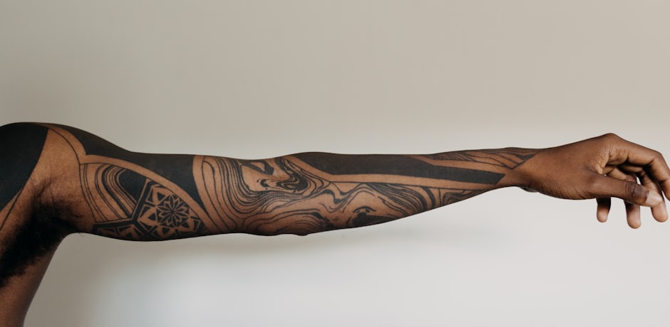 Brazo extendido con una manga tatuada en tinta negra
