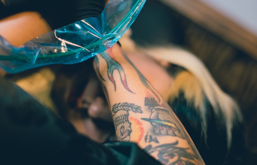 Máquina de tatuar trabajando sobre un tatuaje a color