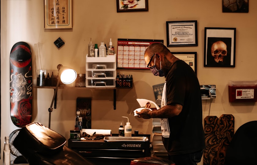 Interior de un estudio de tatuaje con la camilla y láminas en la pared